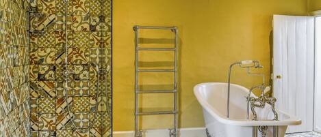 Une salle de bain avec une douche, une baignoire et un carrelage au sol.