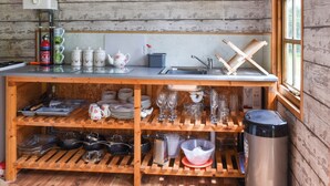 Una cocina rústica con estantes de madera, un lavabo y una ventana.