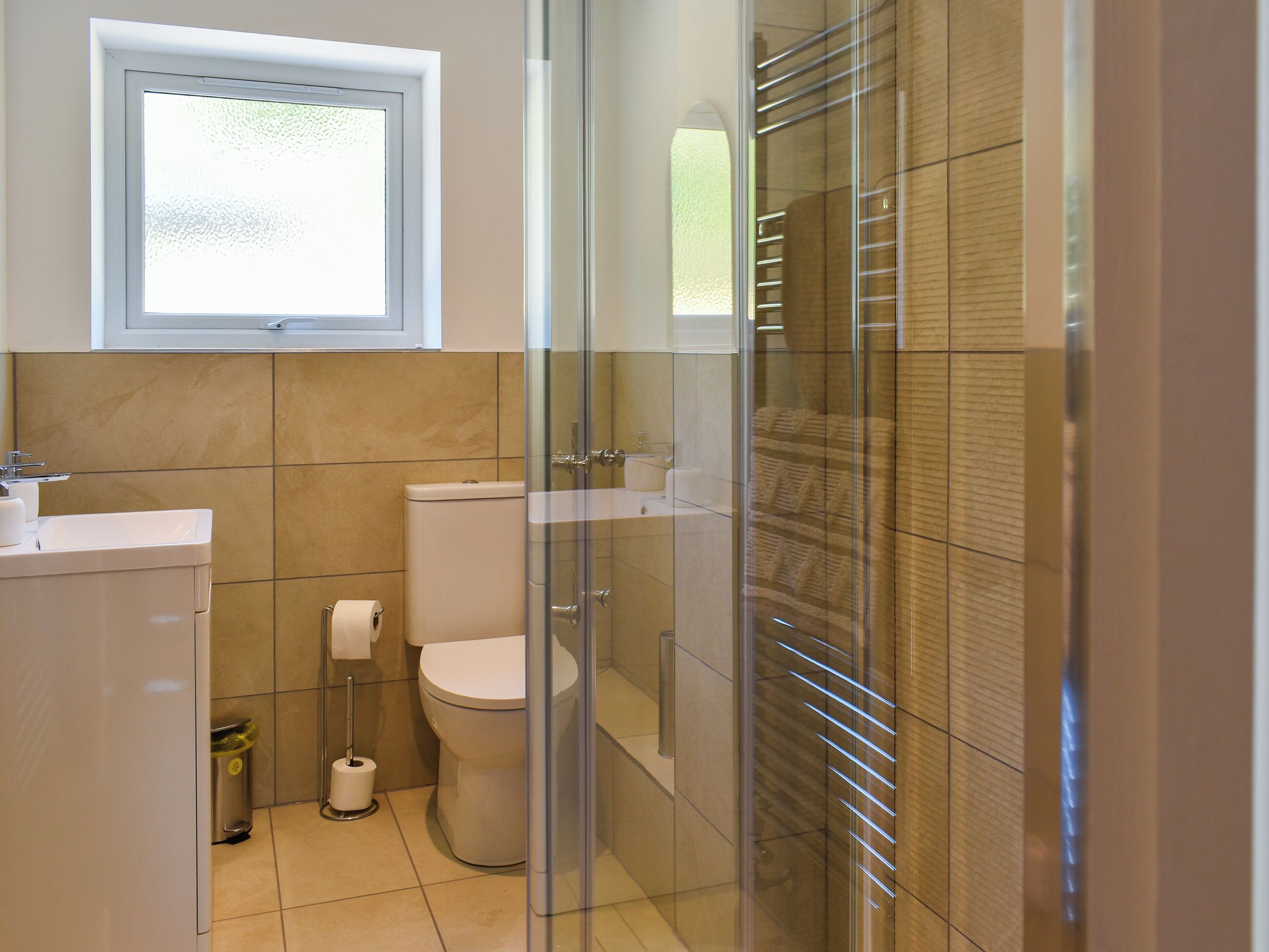 A modern bathroom with a toilet, sink, and shower area.
