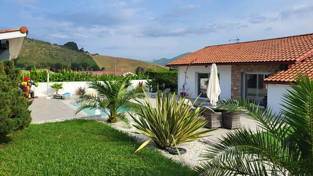 Una proprietà residenziale con piscina, mobili da patio e vista sulle colline circostanti.