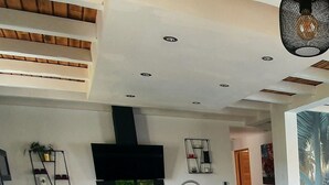 Una cucina moderna con isola centrale, mobili neri e tavolo da pranzo in legno con sedie arancioni.
