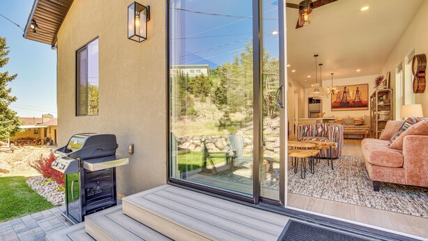 A modern house with a patio, a barbecue grill, and a living room with a sofa and a painting. - Walk to Southern Utah Campus: Home w/ Fire Pit (Cedar City)