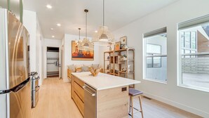 A modern kitchen with a central island, pendant lights, and a view of the outside. - Walk to Southern Utah Campus: Home w/ Fire Pit (Cedar City)