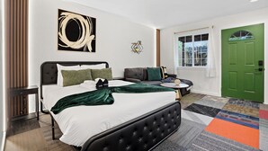 Un dormitorio moderno con una cama grande, un sofá y una puerta verde.