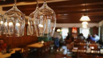 Hanging glass light fixtures in a restaurant with wooden walls and tables.