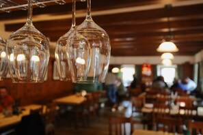Hanging glass light fixtures in a restaurant with wooden walls and tables.