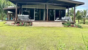 Una casa moderna con un porche cubierto, ventanas amplias y un césped bien cuidado.
