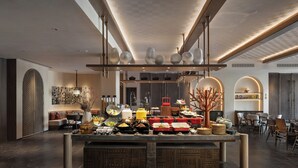 A modern kitchen with a central island, built-in appliances, and a dining area with chairs and tables. - Wanda Vista Ganman Dunhuang (Jiuquan)