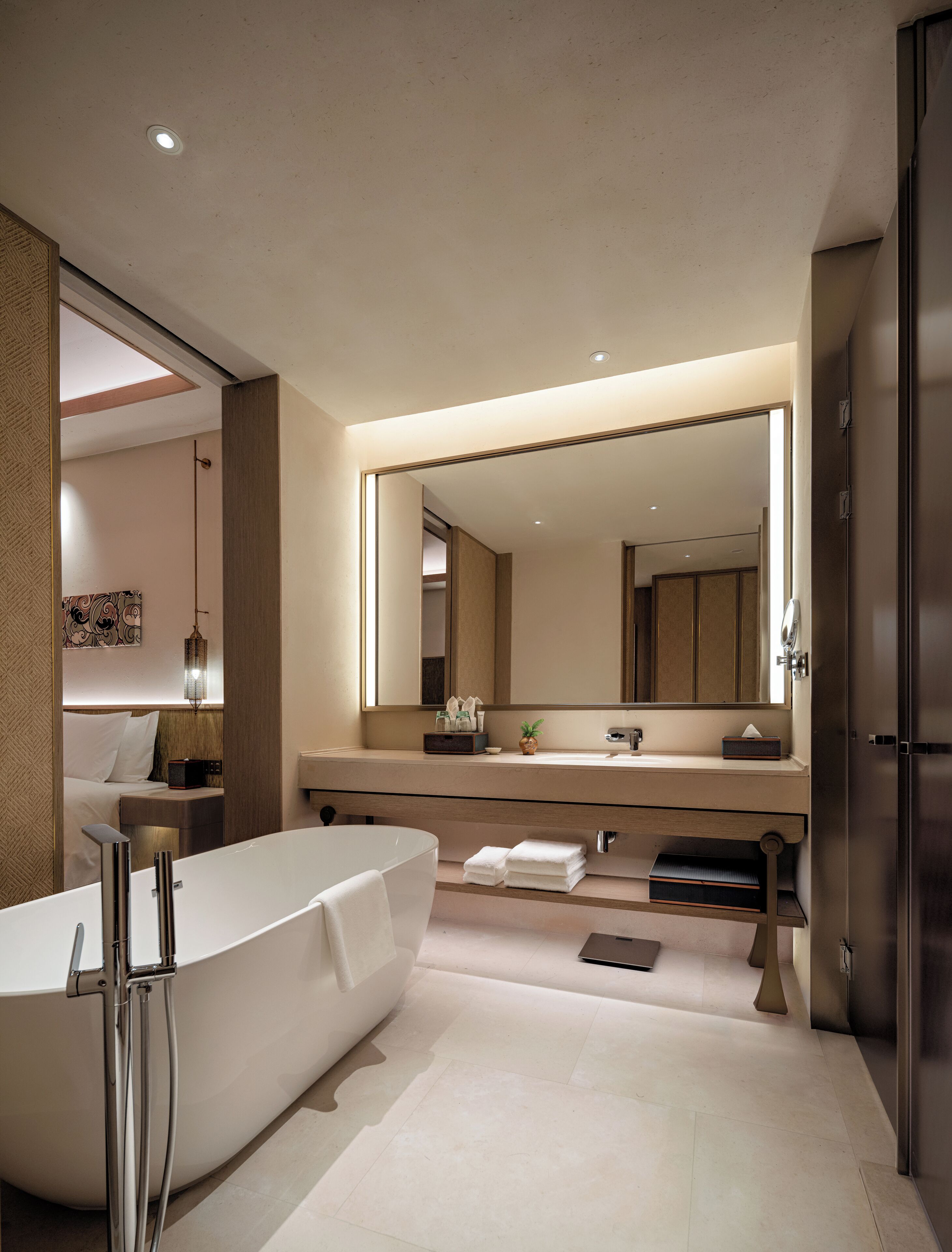 Une salle de bain moderne avec une baignoire sur pieds, un grand miroir et un meuble-lavabo doté d’un évier et d’un porte-serviettes.