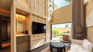 A modern living room with a flat-screen TV, a sofa, a coffee table, and a view of the outdoors. - Wanda Vista Ganman Dunhuang (Jiuquan)