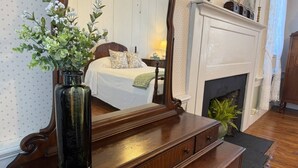 A bedroom with a bed, dresser, mirror, and fireplace. - Stay 3 and play 4 free!!! (Dandridge)