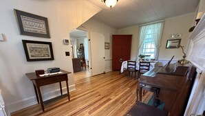 A spacious living room with hardwood floors, a dining area with a table and chairs, and a piano. - Stay 3 and play 4 free!!! (Dandridge)