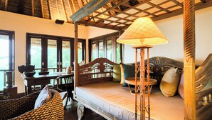 Een houten kamer in traditionele stijl, met een bed, een tafel en een lamp.