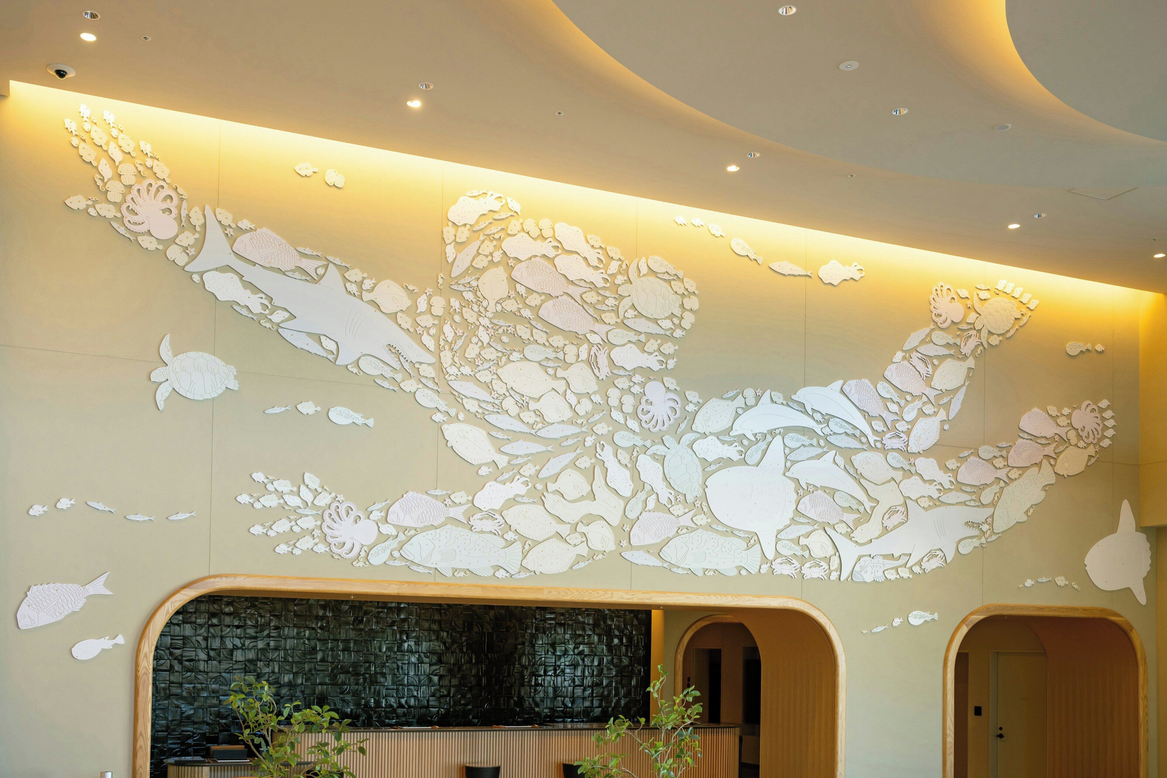 A lobby with a large wall mural, a reception desk, and a seating area.