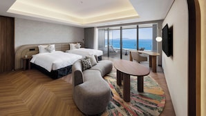 A hotel room with a bed, two bedside tables, a sofa, a small round table, and a TV. - Fukuoka Prince Hotel Momochihama (Fukuoka)