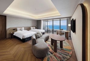 A hotel room with a bed, two bedside tables, a sofa, a small round table, and a TV. - Fukuoka Prince Hotel Momochihama (Fukuoka)
