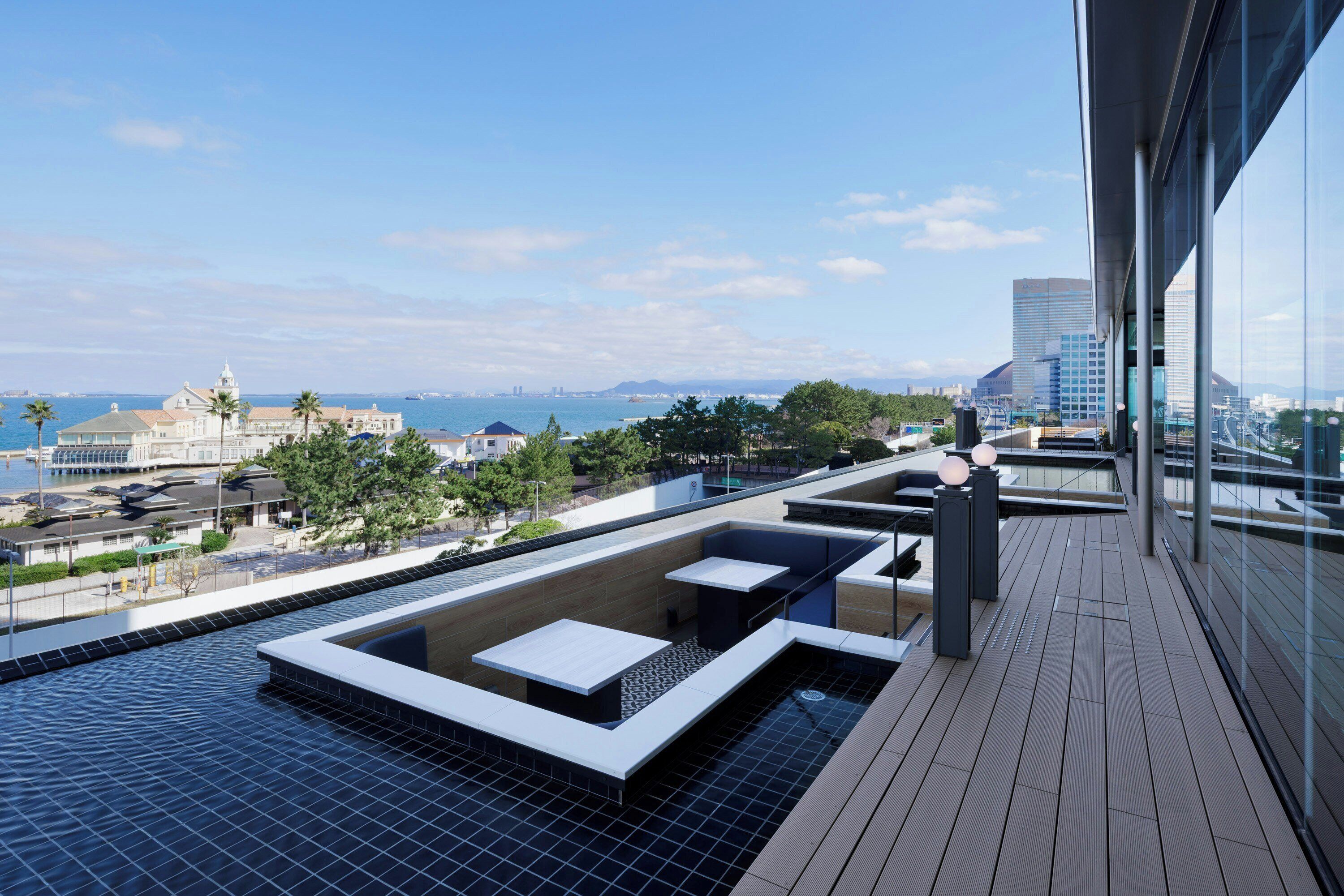Piscina no terraço com vista para a cidade e para o oceano.