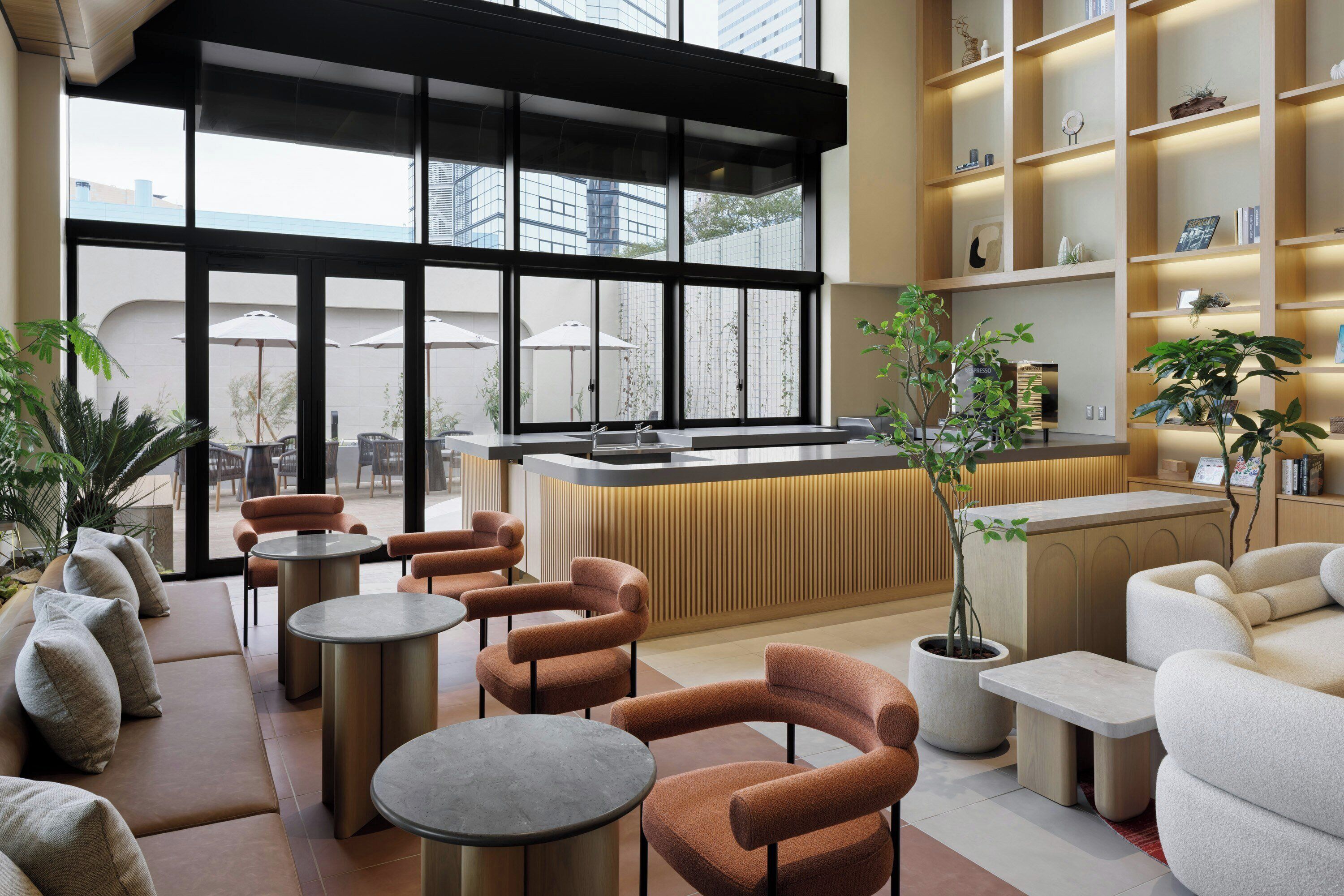 A modern lounge area with sofas, round tables, and a reception desk.