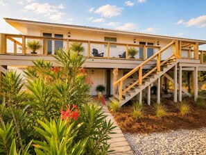 A modern two-story house with a wooden staircase leading to the upper level. - "Shady Pines"- You will have a Golden Time! (Gulf Shores)