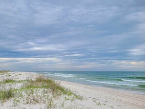A beach with sand dunes and ocean waves under a cloudy sky. - "Shady Pines"- You will have a Golden Time! (Gulf Shores)