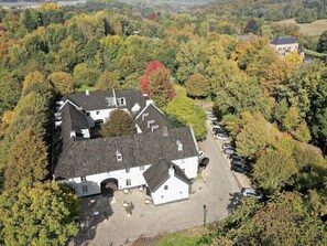 Stunning traditional building surrounded by lush woods, offering a welcoming entrance and scenic views.
