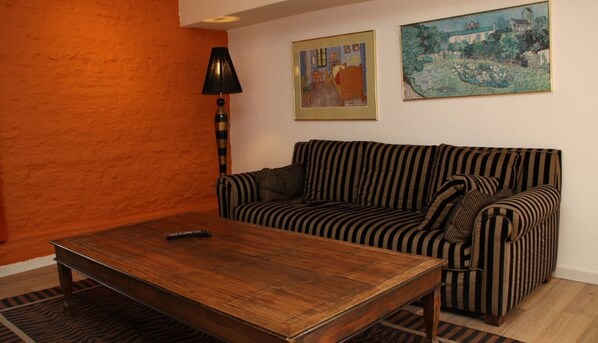 Relax in this inviting living room with a striped sofa, coffee table, and framed artworks on the walls.