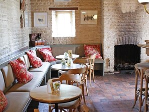 Cozy space with a fireplace, sofa, and dining area.