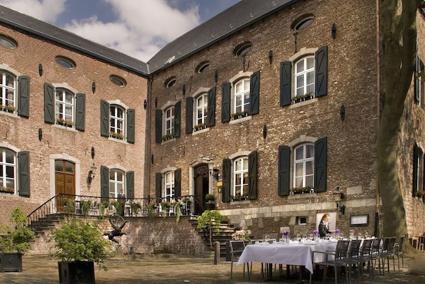 Classic architecture surrounds a charming courtyard with outdoor dining and seating areas.
