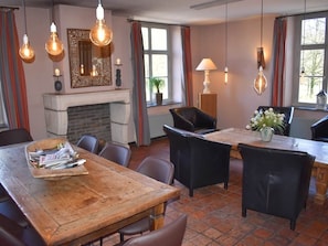 Enjoy meals in this warm dining area with a rustic table, comfortable chairs, and a fireplace.