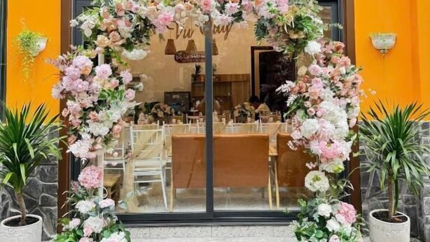 A storefront with a floral archway and potted plants. - Ba Tam Vu Sua (Ho Chi Minh City)