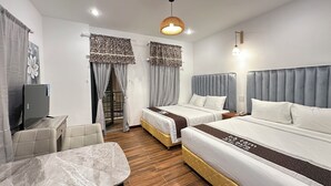A hotel room with two beds, a TV, a table, and a chair. - Ba Tam Vu Sua (Ho Chi Minh City)