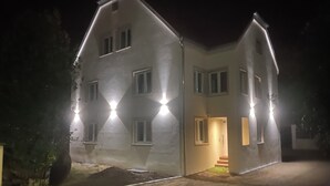 Un bâtiment à deux étages, doté de nombreuses fenêtres et d’une entrée bien éclairée.