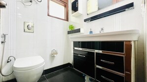 Un baño moderno con inodoro, ducha y tocador con espejo.