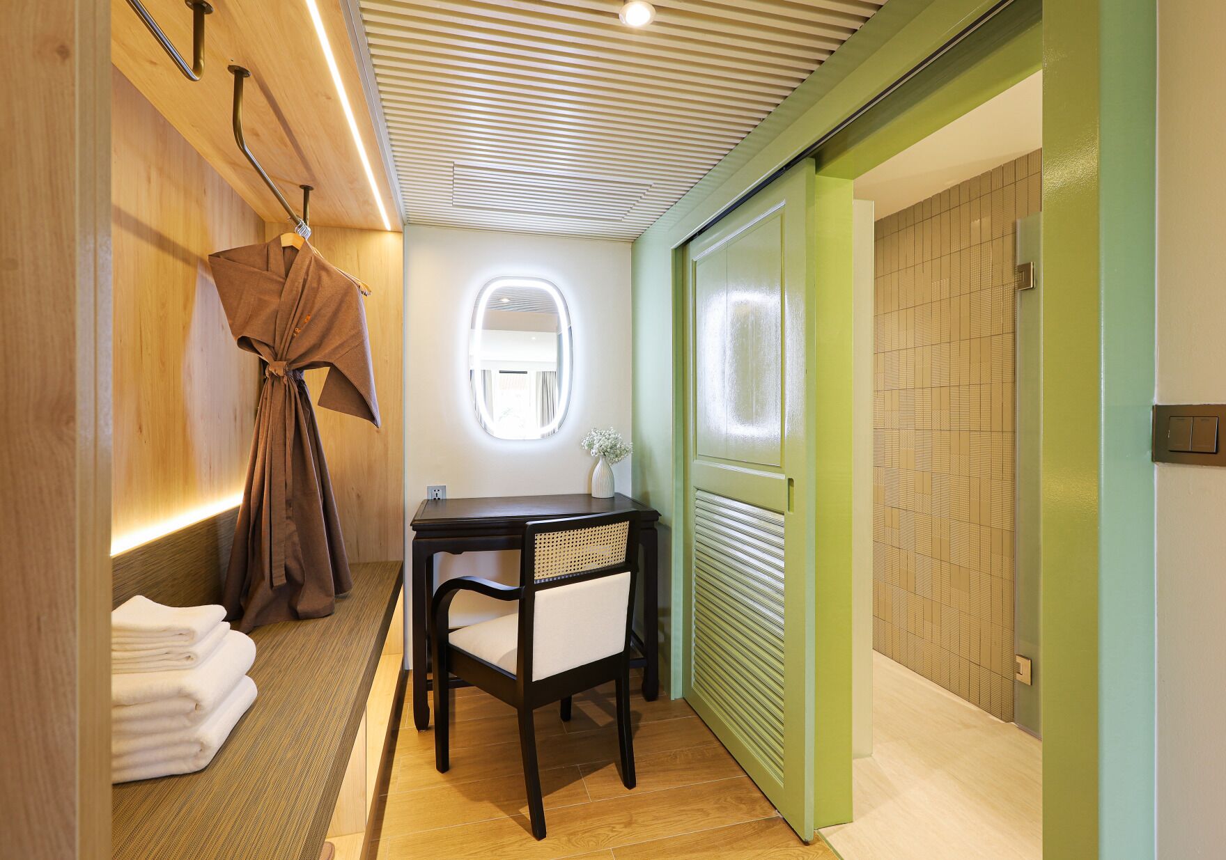 Un baño moderno con tocador de madera, un espejo y un perchero para toallas.