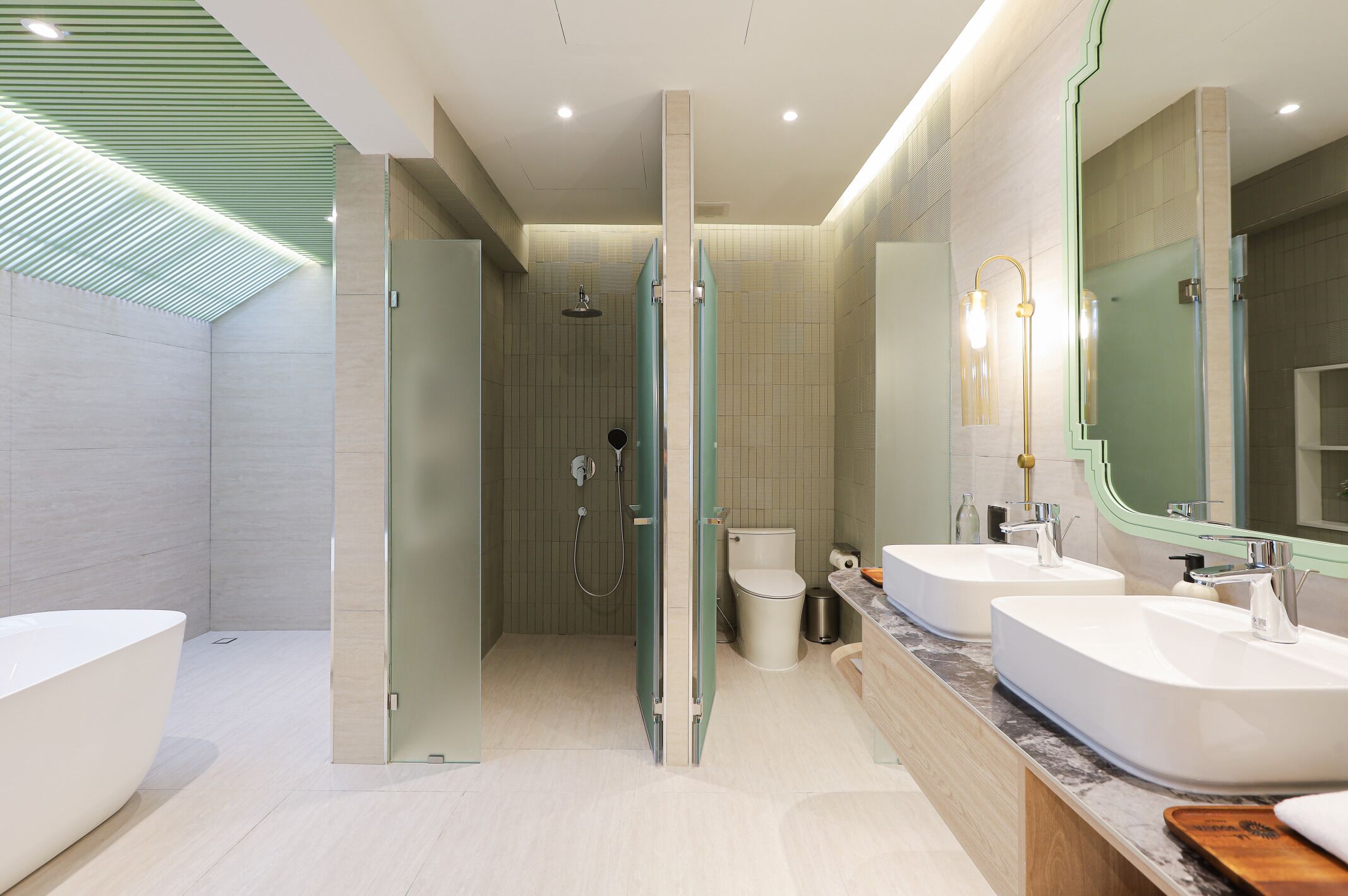 Une salle de bain moderne avec deux lavabos, une douche et des toilettes.