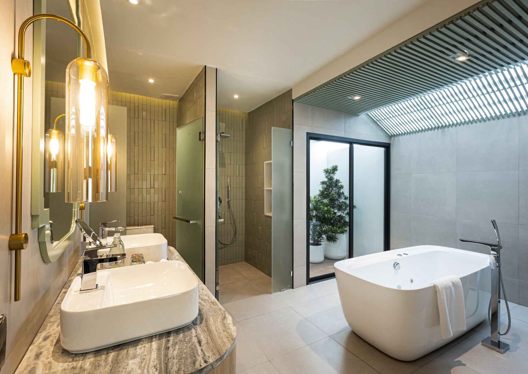 A modern bathroom with a freestanding bathtub, a double sink vanity, and a glass-enclosed shower.