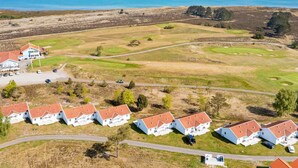 Un quartier résidentiel comprenant plusieurs maisons, un terrain de golf et, au loin, une vaste étendue d’eau.