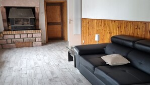 Una sala de estar con chimenea, un sofá y techo de madera.