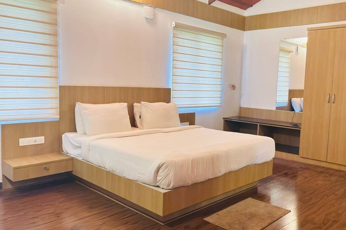 Une chambre à coucher avec un lit en bois, une table de chevet, une armoire et un miroir.