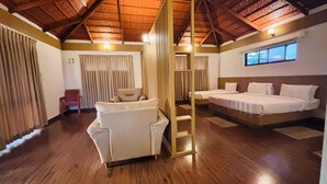 Una habitación con techo de madera, un sofá, una cama y una escalera.