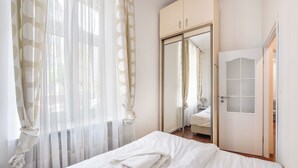 A bedroom with a bed, a wardrobe, and a mirror. - Apartamenty Sun & Snow Przy Monte Cassino (Sopot)