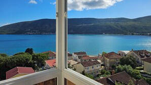 Un pueblo costero con vistas a una gran extensión de agua y colinas al fondo.