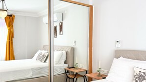 A modern hotel room with a bed, a small desk, a mirror, and a nightstand. - Moonlight Apart Sea View (Kas)