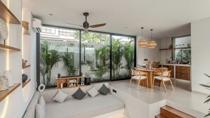 Een moderne woonkamer met een bank, eethoek en keuken.