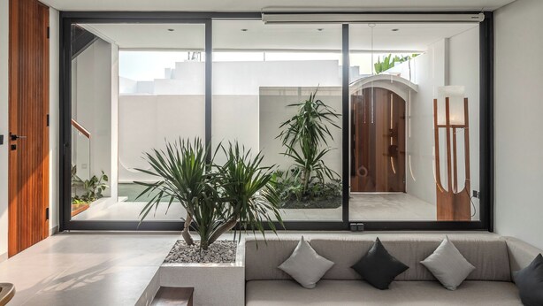 Een moderne woonkamer met een grote schuifpui naar een buitenruimte.