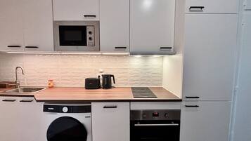 Een microgolfoven, een oven, een kookplaat, een vaatwasser