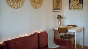 A living room with a sofa, a coffee table, and a dining area with chairs and a table.