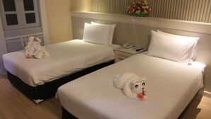Two adjacent hotel beds with white linens, a bedside table with a phone, and a decorative floral arrangement on the wall. - Vwish Hotel Khon Kaen (Khon Kaen)