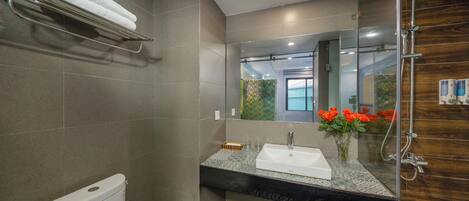 A modern bathroom with a toilet, sink, and shower.