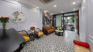 Un intérieur moderne avec une table de salle à manger ronde, un canapé marron et un sol à motifs.
